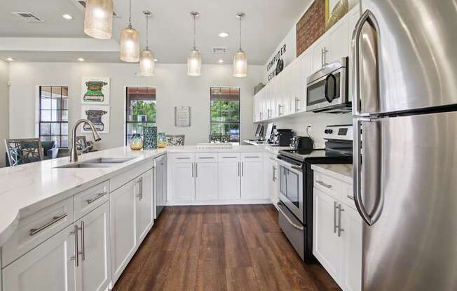 A modern kitchen with white cabinets and stainless steel appliances.