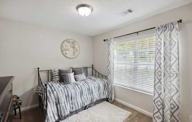 a bedroom with a bed and a large window