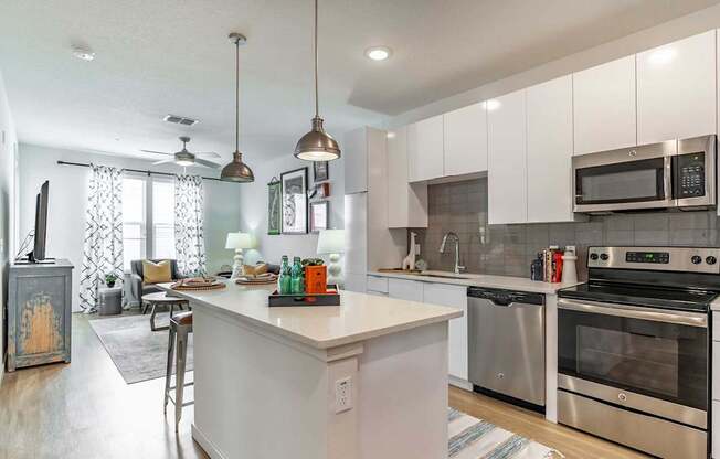 A kitchen with white cabinets and a white island.