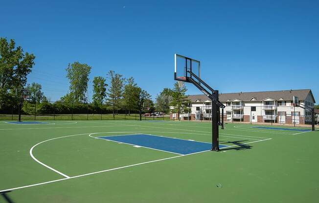 a basketball court with a house in the background