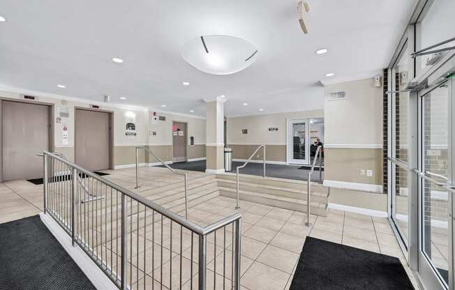 a large lobby with stairs and glass doors