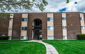 A large brick building with a green lawn in front.