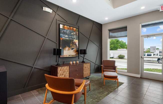 A room with a brown chair and a painting on the wall.
