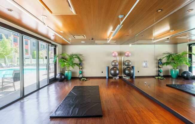 A yoga studio with wooden floors and mirrors on the wall.