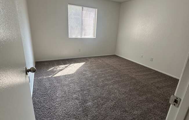 a room with a window and a white wall and a bath tub