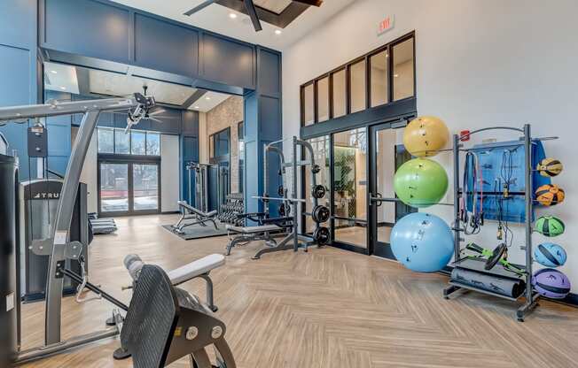 a gym with cardio equipment and weights on the floor and glass doors