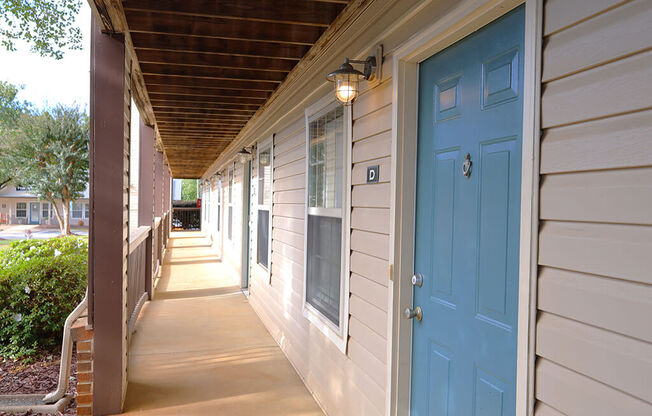 the front porch of a house with a blue door