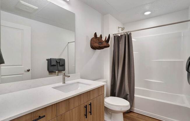A white sink in a bathroom with a towel hanging on the wall.