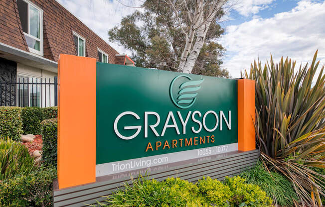 a sign with a green background and an orange background with the words grayson apartments