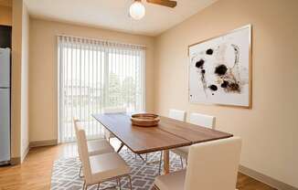 A dining room with a wooden table and chairs.