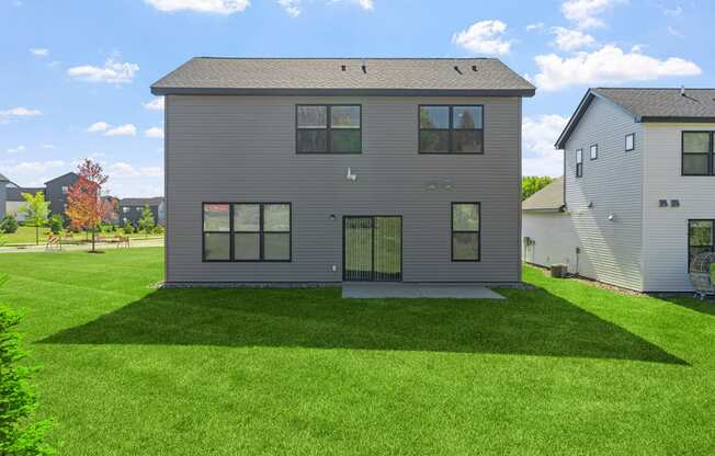 the back of a house with a green lawn