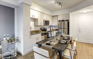 A modern kitchen with a dining table set for two.