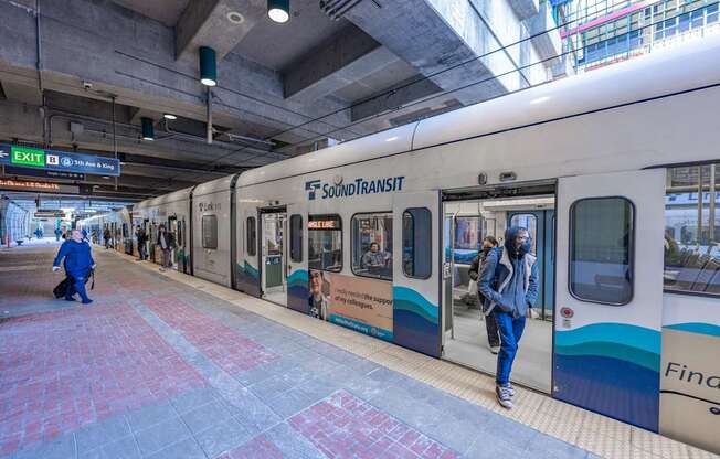 a subway train at a station with doors open and passengers exiting