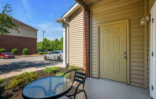 a patio with a table and chairs and a yellow door