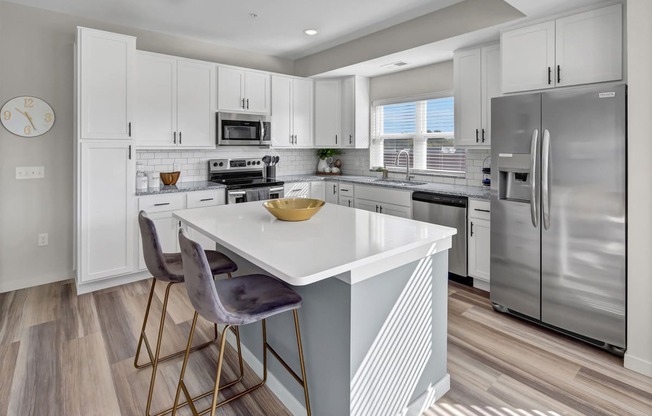 a white kitchen with stainless steel appliances and a white counter top