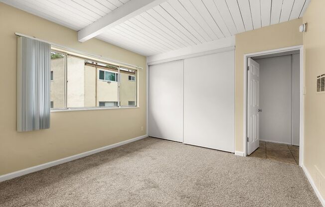 a bedroom with beige walls and a white ceiling