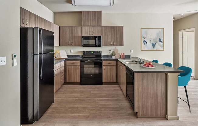 A kitchen with black appliances and wooden cabinets.