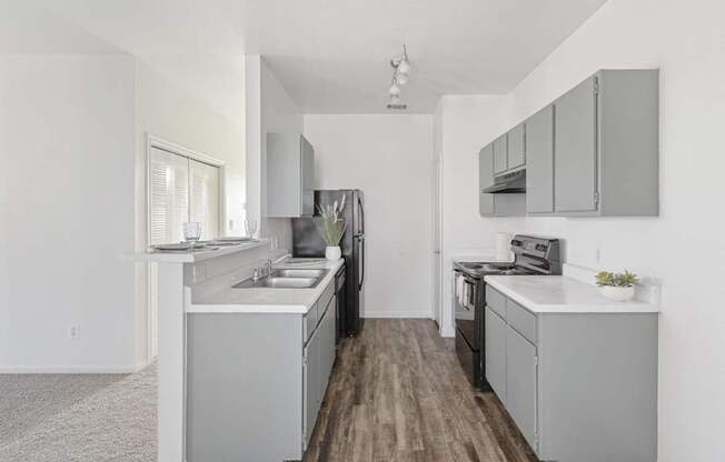 Affordable Apartments in Austin, TX for Rent- Huntington Meadows-  A kitchen with a white counter top and grey cabinets.