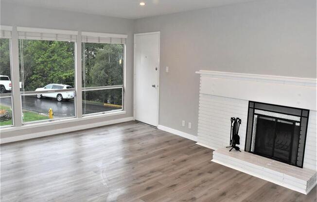 a living room with a fireplace and a large window