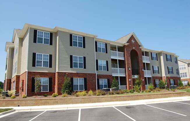 A large apartment complex with a parking lot in front.