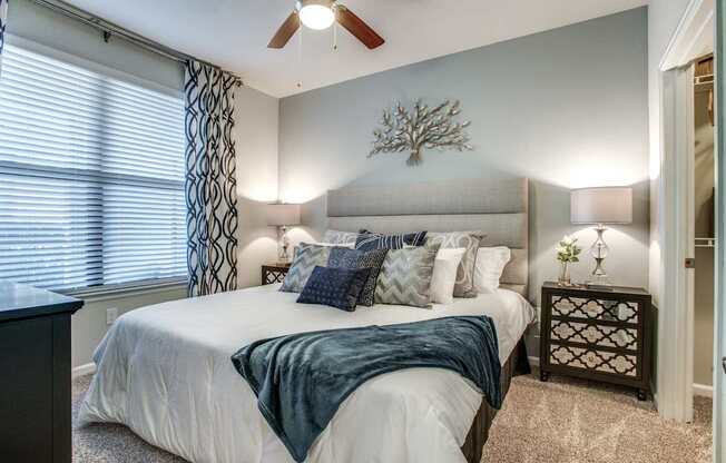 A bedroom with a bed, nightstand, and window.