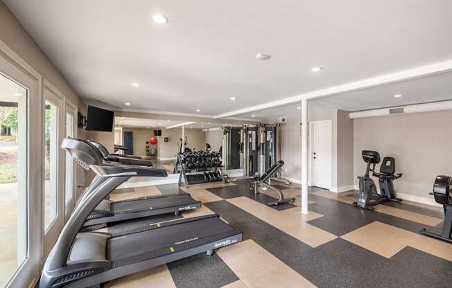 A spacious home gym with treadmills, weights, and exercise equipment.