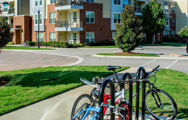 A blue bicycle is parked next to a red bicycle on a sidewalk.
