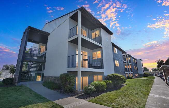 A modern apartment building with a balcony and a walkway in front.