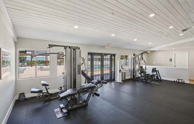 A gym with a view of the pool outside.