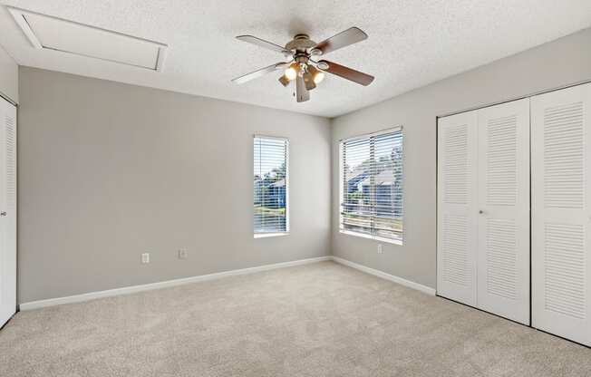 Model bedroom with ceiling fan and carpet at Huntington Place in Sarasota, Florida.