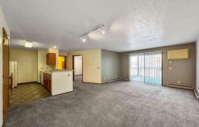 the living room and kitchen of an empty apartment