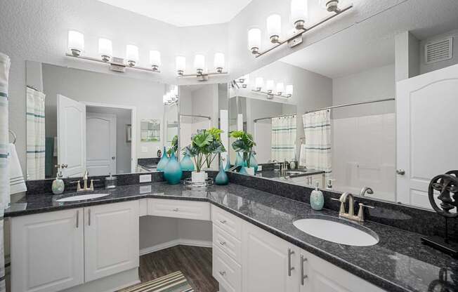 A bathroom with two sinks and a large mirror.