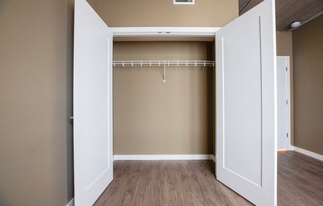 an empty closet with a white door and brown walls