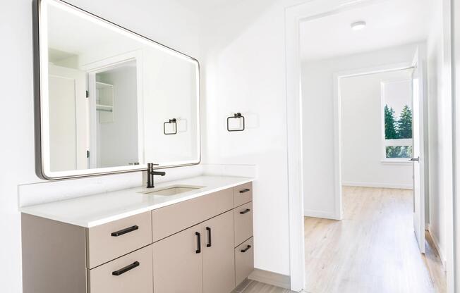 Modern bathrooms feature quartz countertops, sleek flat-panel cabinetry, illuminated mirrors, and contemporary fixtures that create a clean, refined aesthetic.