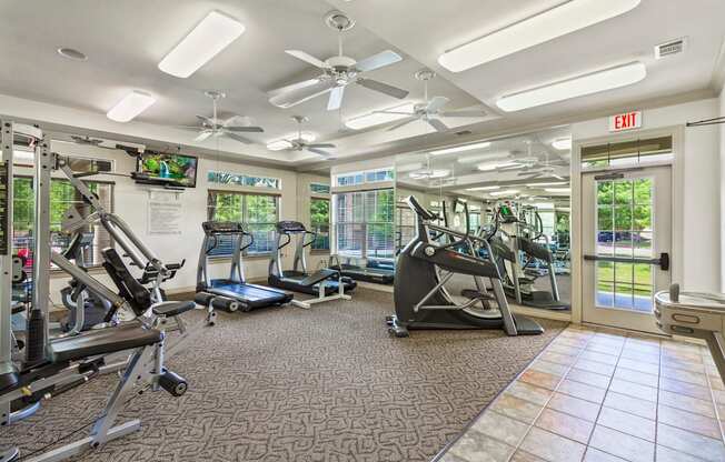 A gym with a variety of equipment including treadmills, stationary bikes, and weight machines.