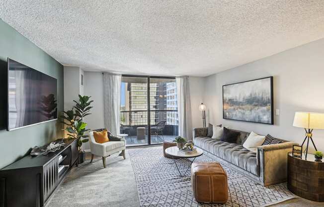 a living room with a couch and a tv and a balcony