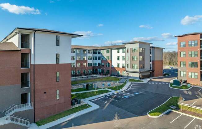 A large building complex with a parking lot in front.