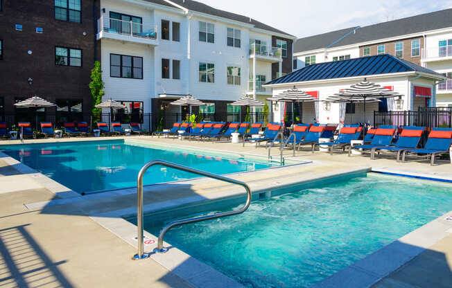 A swimming pool with a slide and sun loungers.