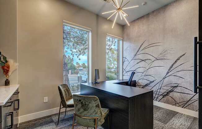 a home office with a large window and a desk with chairs