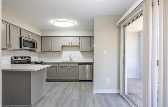 a renovated kitchen with stainless steel appliances and white cabinets