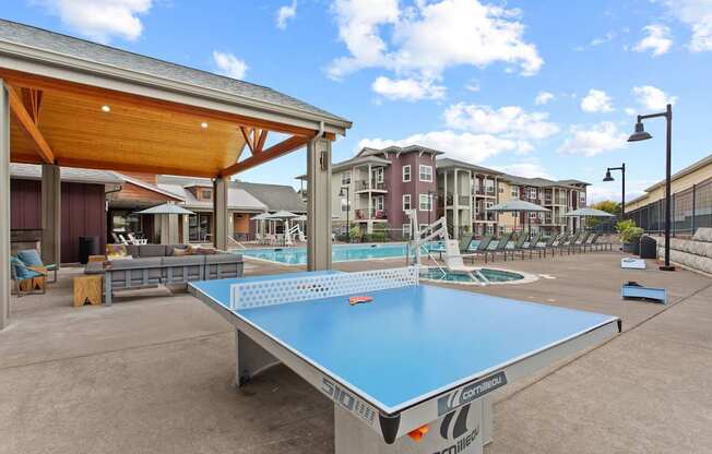 A ping pong table is in the middle of a courtyard.