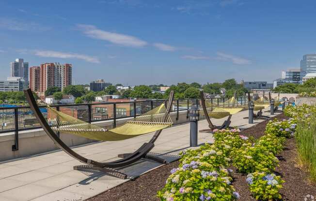 a row of hammocks on a rooftop overlooking the city