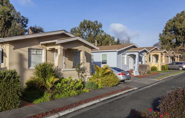 a row of houses with cars parked in front of them