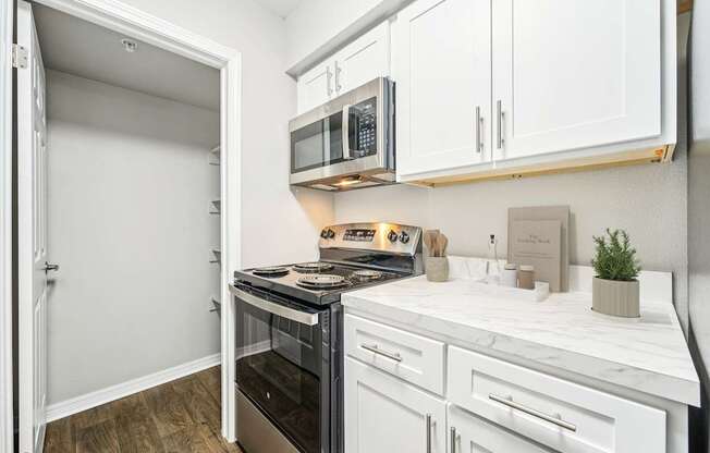 A kitchen with white cabinets and a black stove top oven.