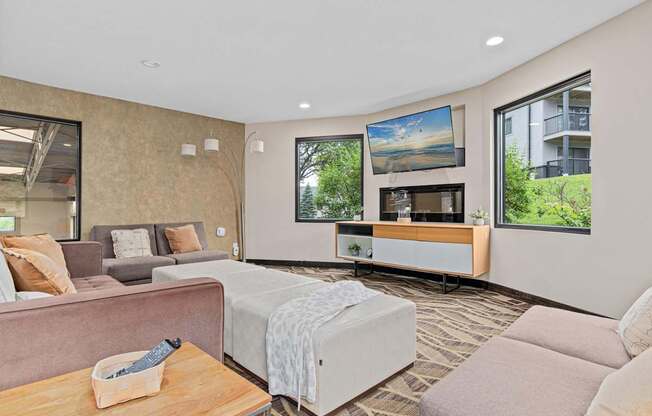 A living room with a couch, a coffee table, and a large window.