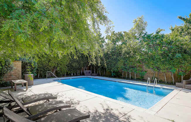 a swimming pool with two chairs next to it