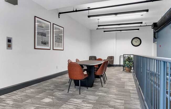 A conference room with a table, chairs, and pictures on the wall.