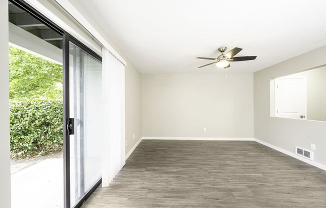 a bedroom with a sliding glass door and a ceiling fan