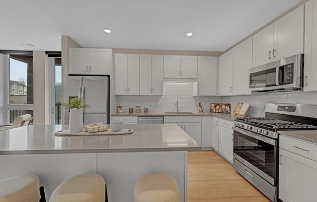 a kitchen with white cabinets and stainless steel appliances