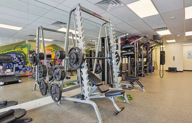 A gym with a variety of equipment including dumbbells and weight machines.